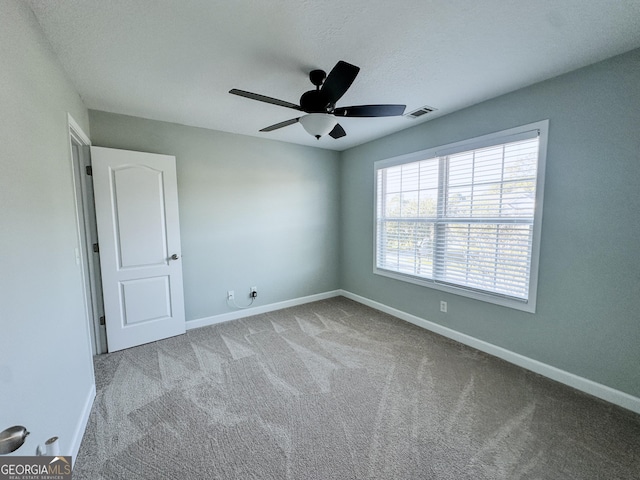 unfurnished room with light colored carpet and ceiling fan