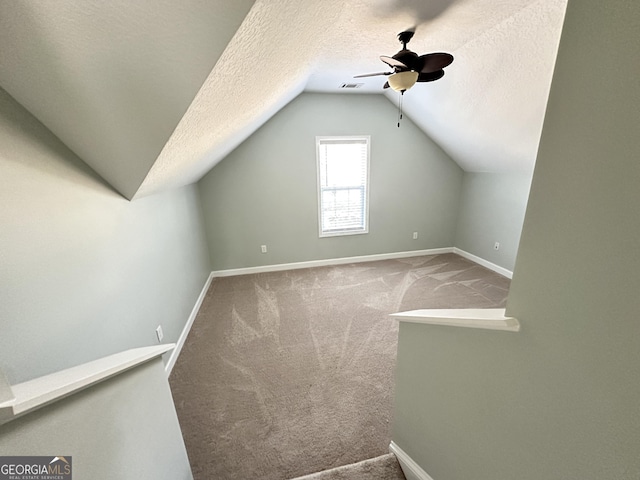 additional living space with carpet flooring, ceiling fan, a textured ceiling, and vaulted ceiling