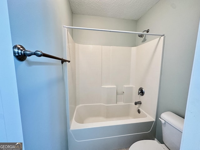 bathroom featuring bathtub / shower combination, a textured ceiling, and toilet