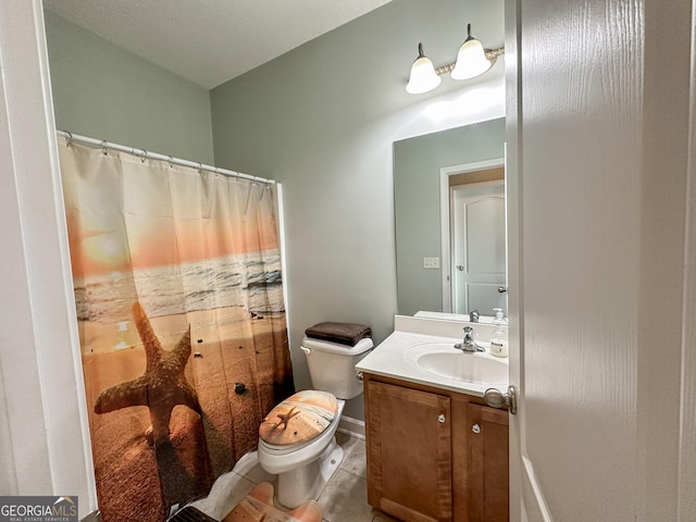 bathroom featuring tile patterned flooring, vanity, and toilet