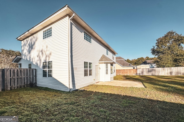 back of house with a patio area and a yard