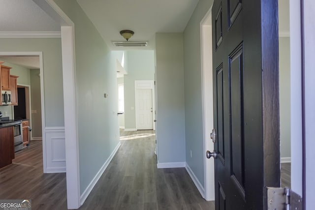 corridor with crown molding and dark wood-type flooring