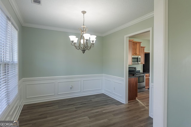 unfurnished dining area featuring a chandelier, crown molding, and dark wood-type flooring