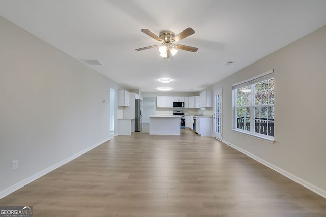 unfurnished living room with ceiling fan, light hardwood / wood-style flooring, and sink