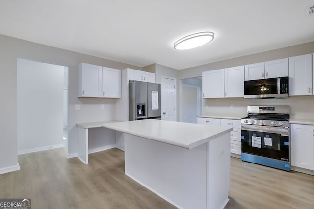 kitchen with white cabinets, a center island, light hardwood / wood-style floors, and appliances with stainless steel finishes