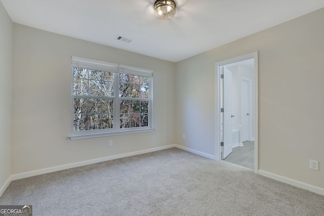 spare room featuring light colored carpet