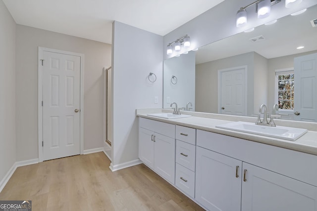 bathroom featuring vanity, an enclosed shower, and wood-type flooring