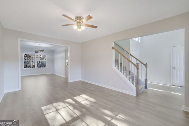 unfurnished living room featuring ceiling fan and light wood-type flooring