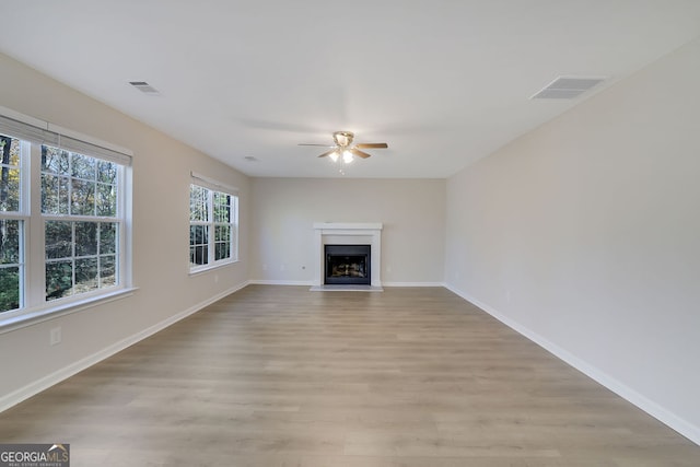 unfurnished living room featuring ceiling fan and light hardwood / wood-style flooring