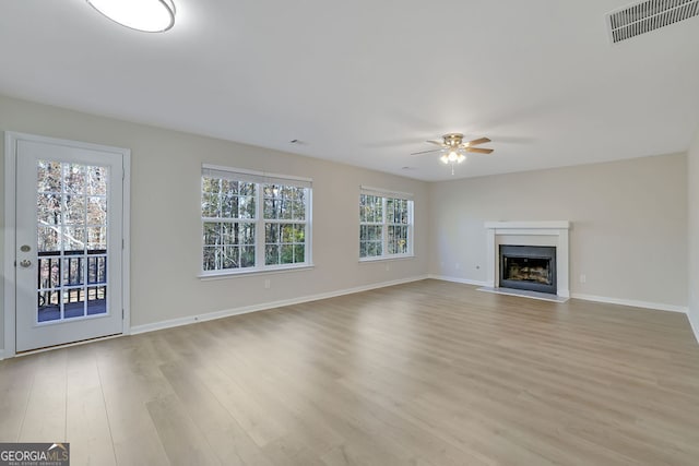 unfurnished living room with light hardwood / wood-style flooring and ceiling fan