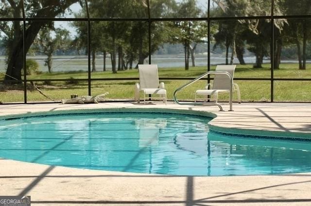 3917 Harris Neck Rd NE, Townsend, GA 31331 - outdoor pool with glass enclosure, a patio, and a lawn