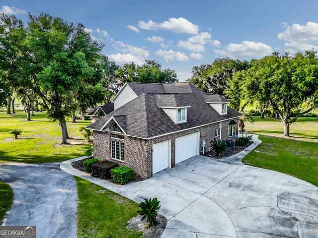 view of side of property with a yard and a garage