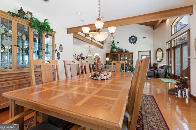 dining area with beam ceiling and a chandelier