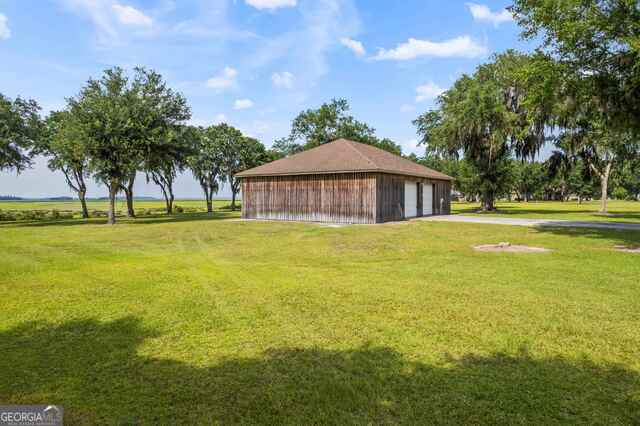 view of community featuring an outdoor structure and a lawn