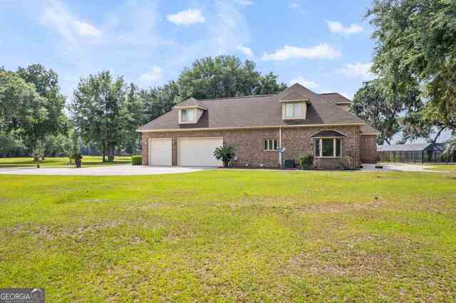 cape cod home with a front yard and a garage