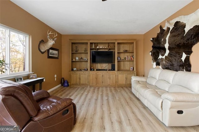 living area with light wood-style flooring and baseboards