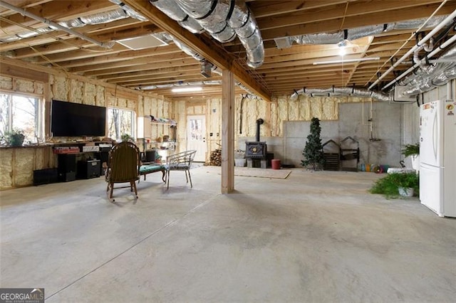 below grade area with a wood stove and freestanding refrigerator