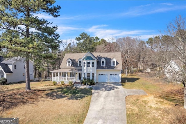 view of front of house with an attached garage, covered porch, concrete driveway, and a front yard