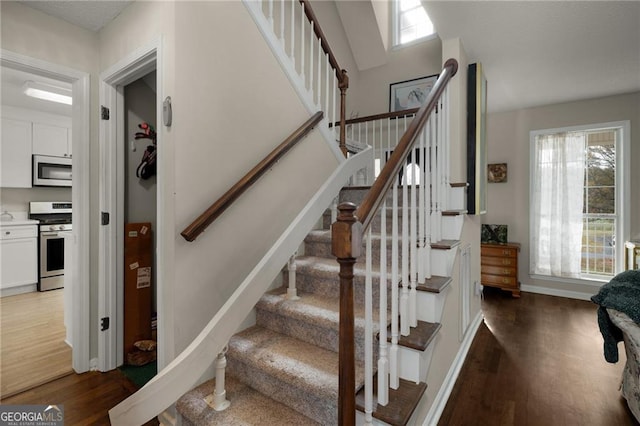 stairs with baseboards and wood finished floors