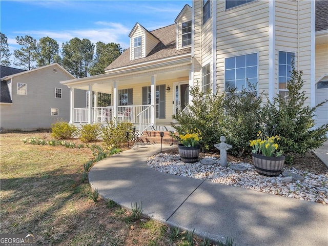 exterior space with covered porch and roof with shingles