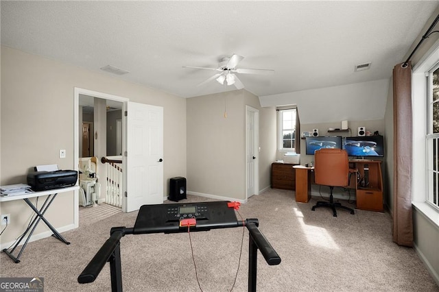 exercise area featuring visible vents, baseboards, carpet flooring, and a ceiling fan