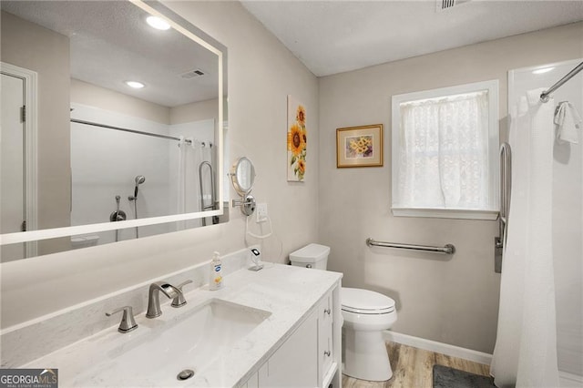 bathroom featuring vanity, a shower with curtain, wood finished floors, visible vents, and toilet