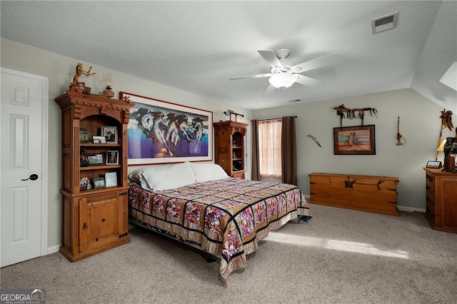 carpeted bedroom with visible vents, baseboards, ceiling fan, vaulted ceiling, and a textured ceiling