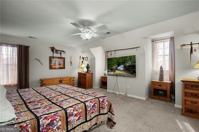 bedroom featuring baseboards, visible vents, carpet floors, and a textured ceiling