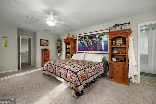 bedroom featuring baseboards, ceiling fan, carpet, ensuite bathroom, and a textured ceiling