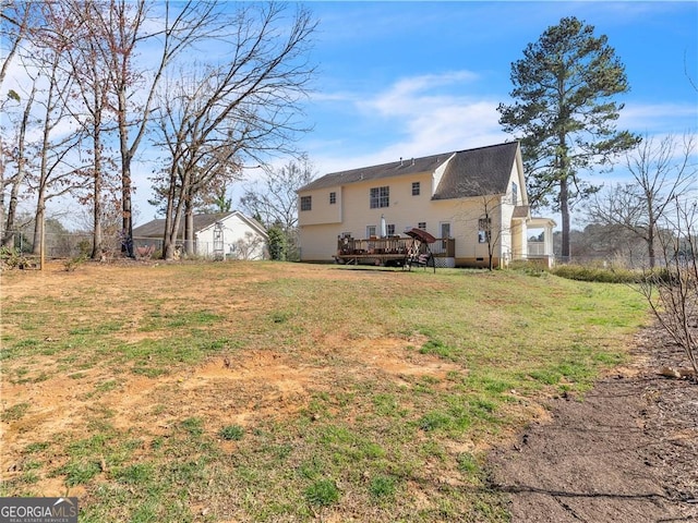 rear view of house with a lawn and a deck