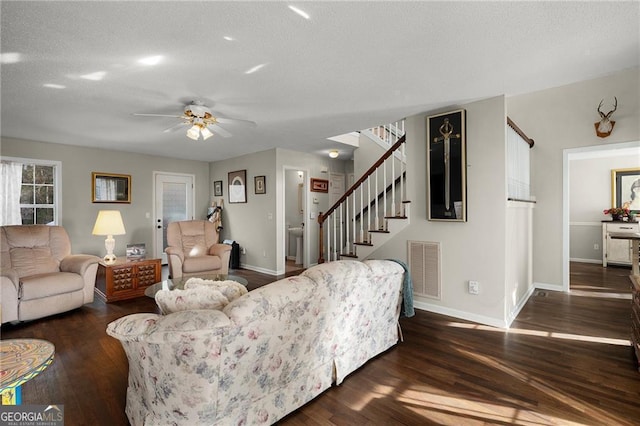 living area with visible vents, a ceiling fan, wood finished floors, stairway, and baseboards