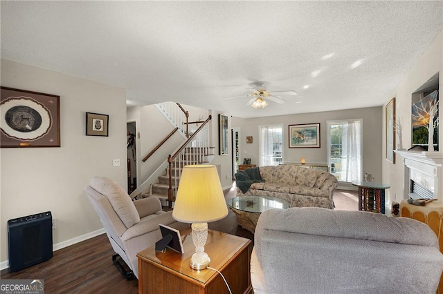 living area featuring dark wood-style floors, a textured ceiling, stairs, and ceiling fan