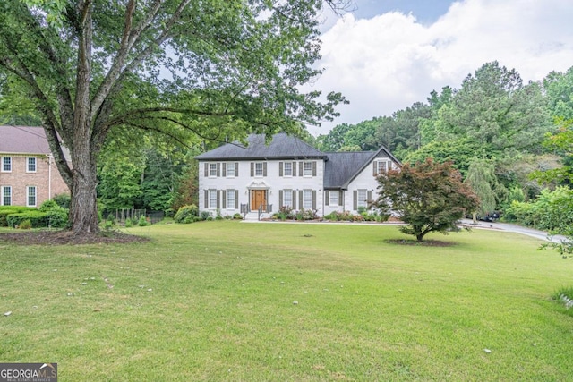 colonial inspired home featuring a front lawn