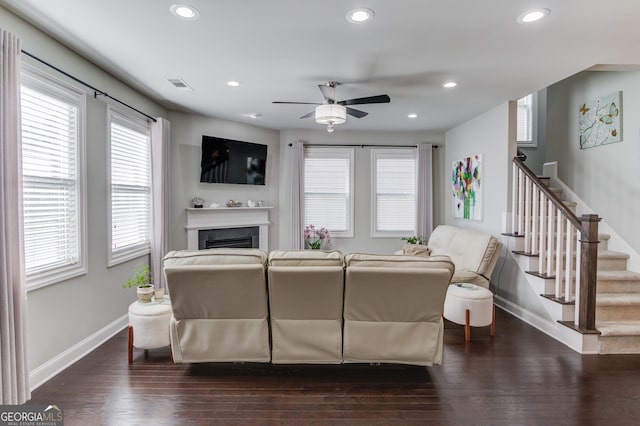 living room with dark hardwood / wood-style flooring and ceiling fan