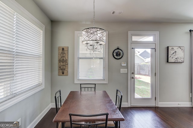 dining area featuring dark hardwood / wood-style floors and an inviting chandelier