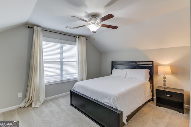 bedroom with ceiling fan, light colored carpet, and vaulted ceiling