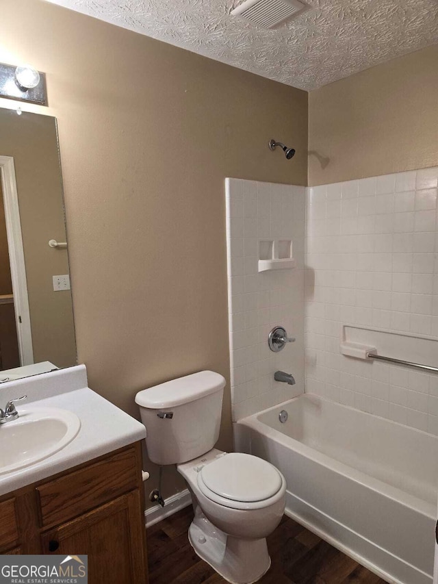 full bathroom with vanity, wood-type flooring, a textured ceiling, and bathing tub / shower combination