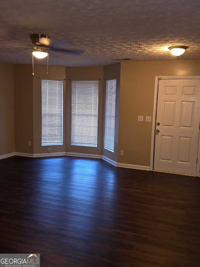 spare room with ceiling fan, dark hardwood / wood-style flooring, and a textured ceiling