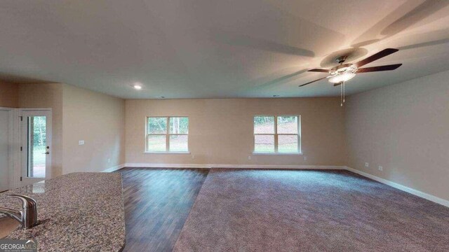 unfurnished room featuring dark hardwood / wood-style flooring, a wealth of natural light, and ceiling fan