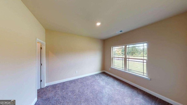 empty room with vaulted ceiling and dark carpet