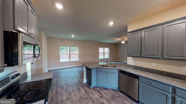 kitchen featuring ceiling fan, sink, hardwood / wood-style floors, gray cabinets, and appliances with stainless steel finishes