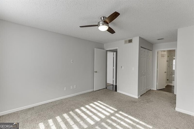 unfurnished bedroom with ceiling fan, a closet, light carpet, and a textured ceiling