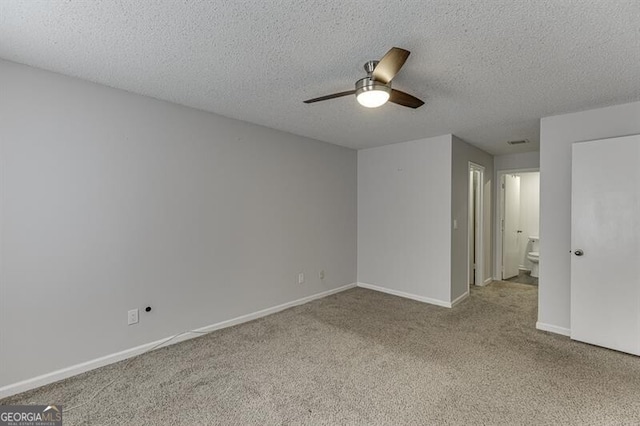 carpeted spare room featuring ceiling fan and a textured ceiling