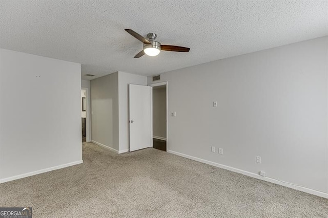 spare room featuring ceiling fan, a textured ceiling, and light carpet