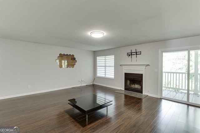 unfurnished living room with dark hardwood / wood-style flooring and plenty of natural light