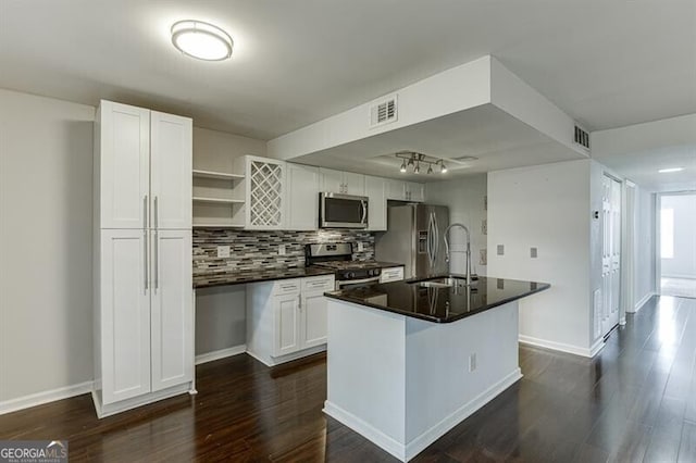 kitchen featuring appliances with stainless steel finishes, dark hardwood / wood-style flooring, sink, white cabinets, and a center island