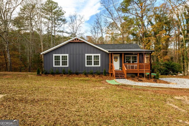 ranch-style home with covered porch and a front yard