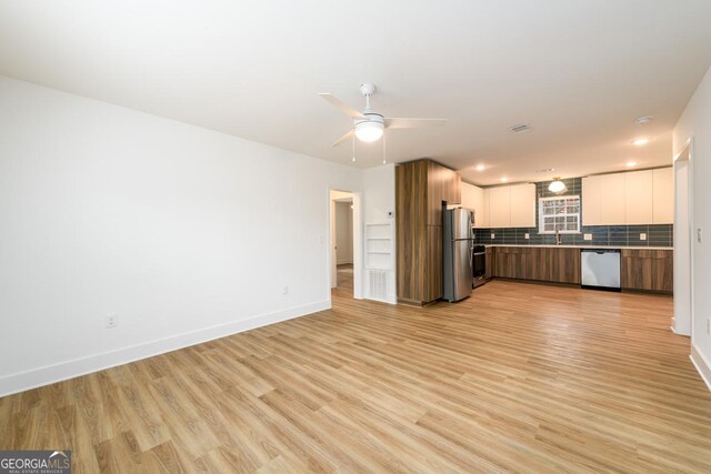 kitchen featuring white cabinets, decorative backsplash, ceiling fan, appliances with stainless steel finishes, and light hardwood / wood-style floors