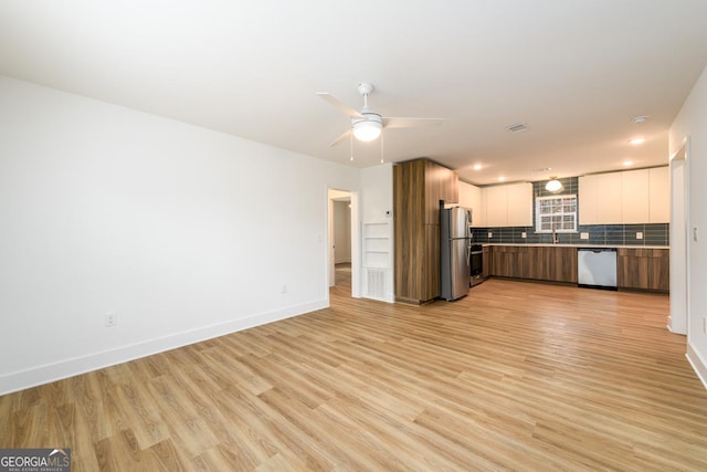 kitchen featuring ceiling fan, stainless steel appliances, light hardwood / wood-style floors, white cabinets, and decorative backsplash