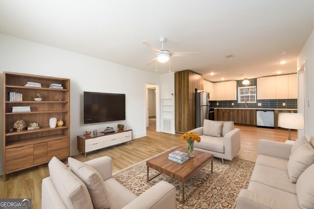 living room with ceiling fan and light wood-type flooring